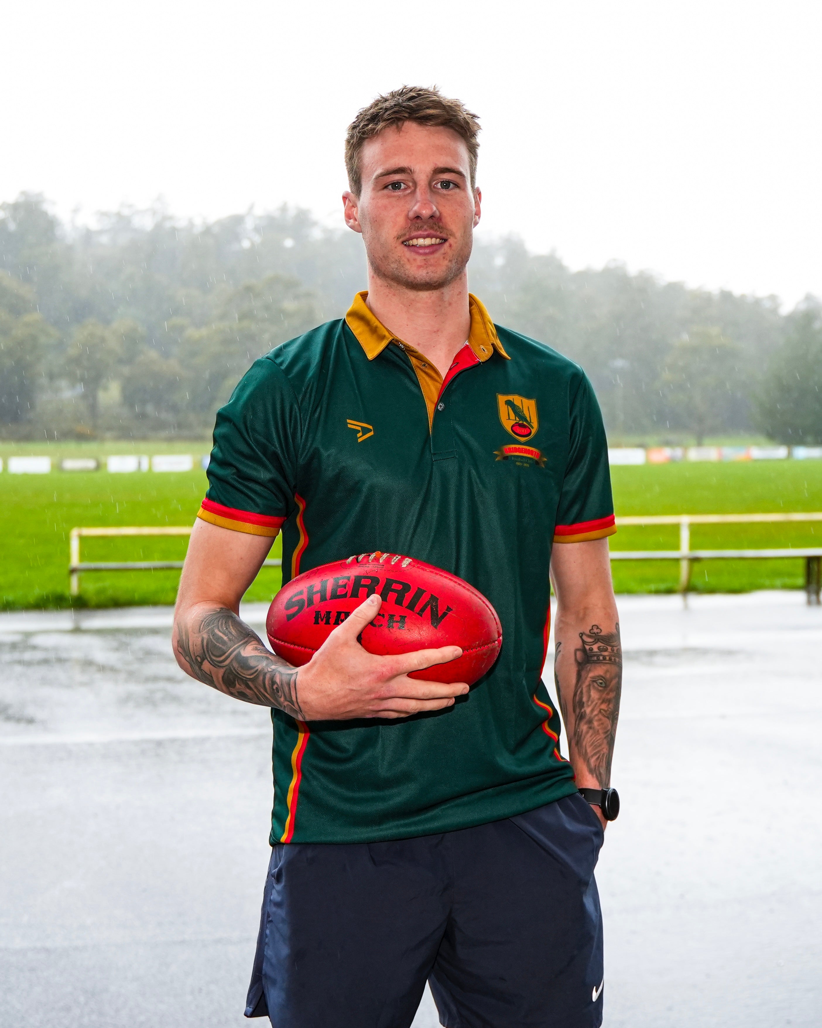 Bailey Mitchell holding a red football wearing a Birdgenorth polo top with a blurred background