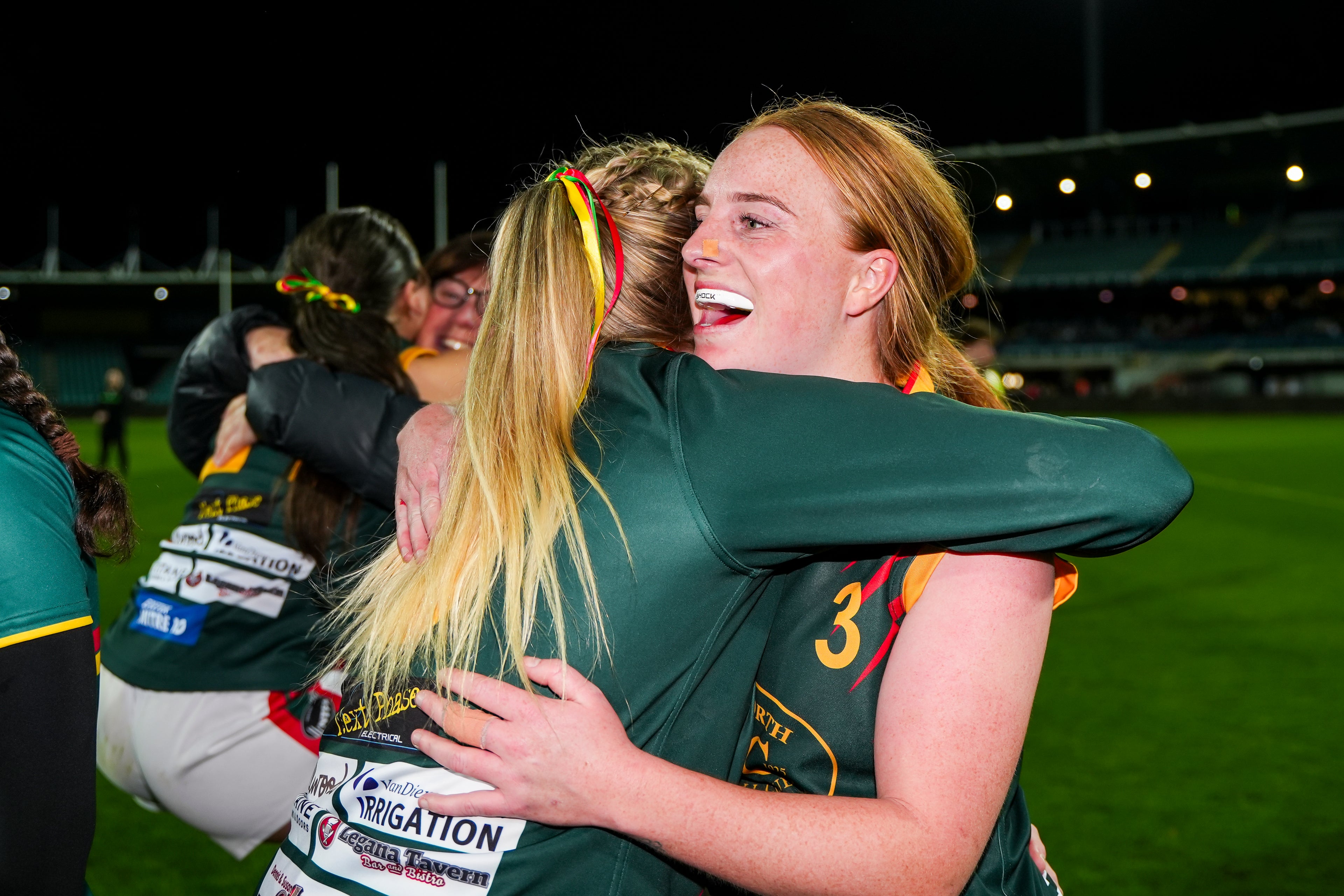 Two womens team players hugging after winning the premiership
