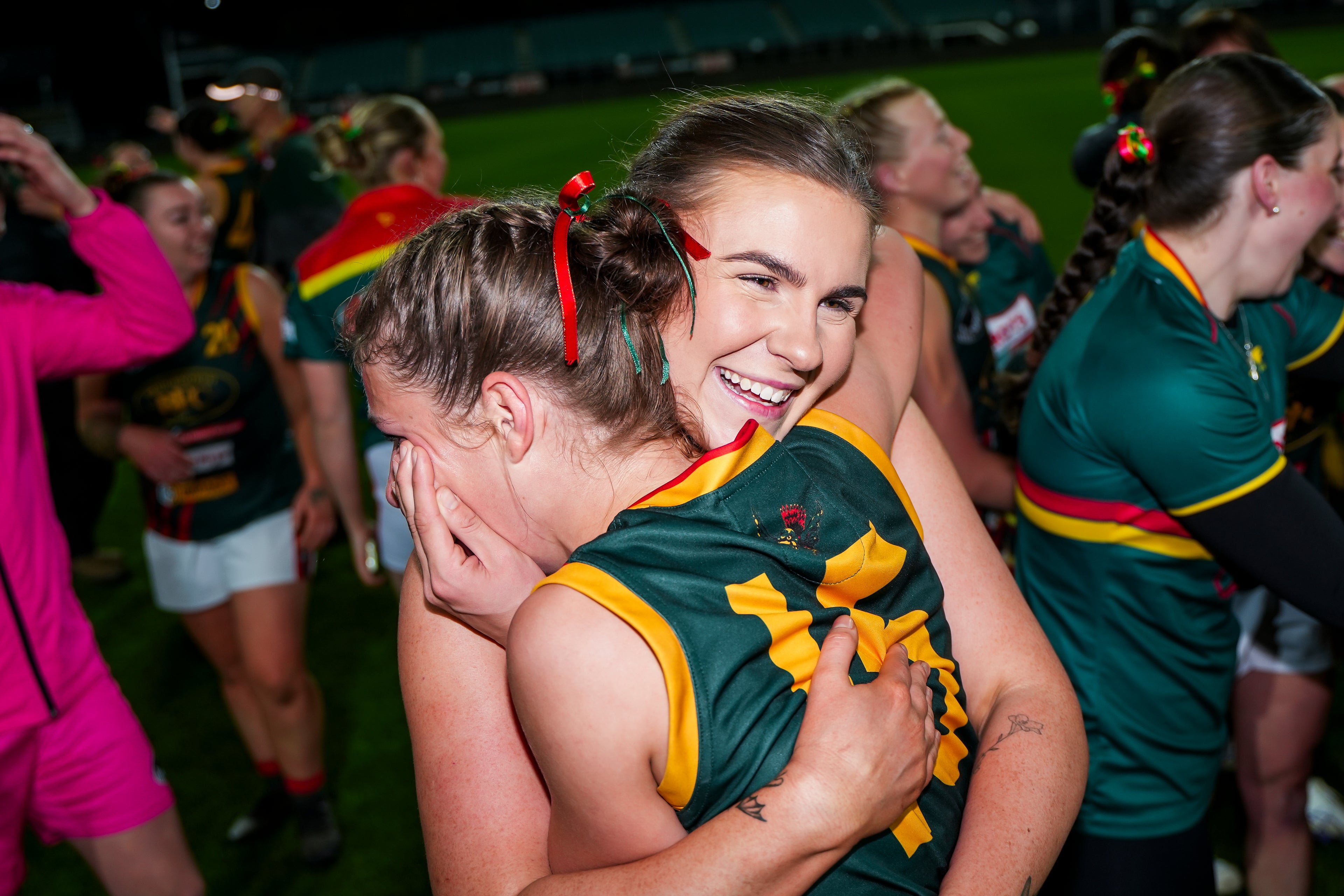 Two Womens players celebrating the grand final win