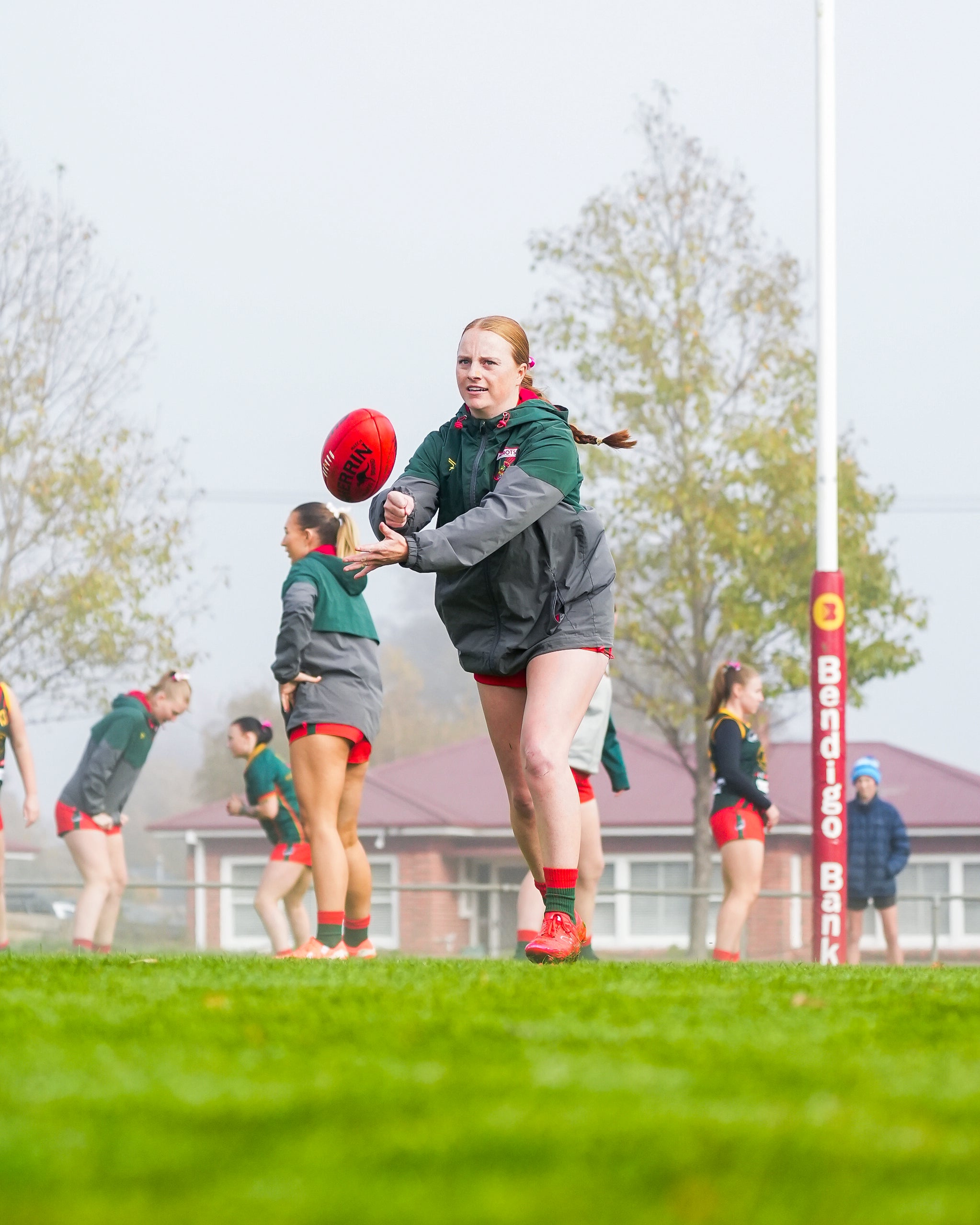 Jenna Griffiths handballing the football in the fog
