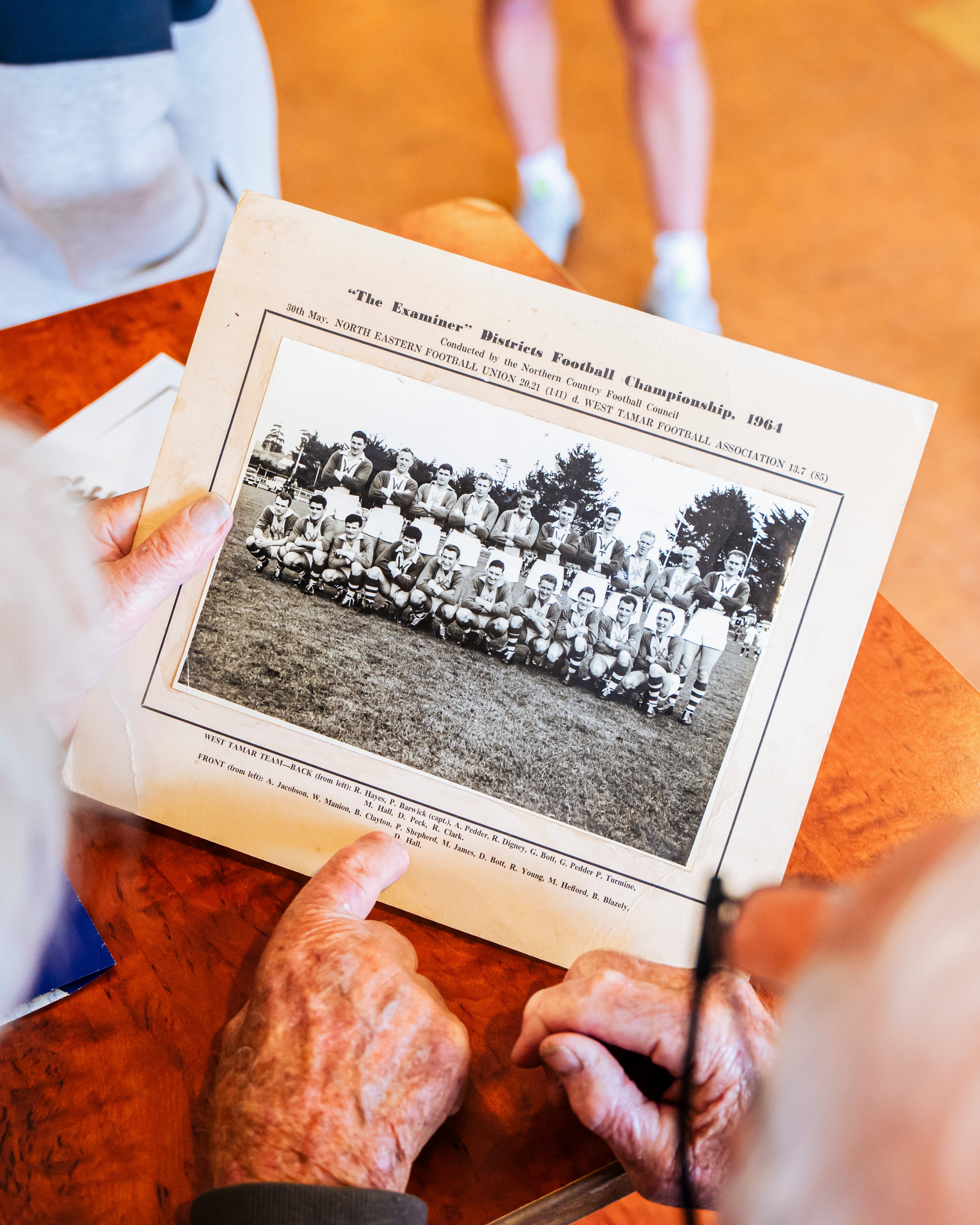 Person holding a book with a black and white photograph of a football team